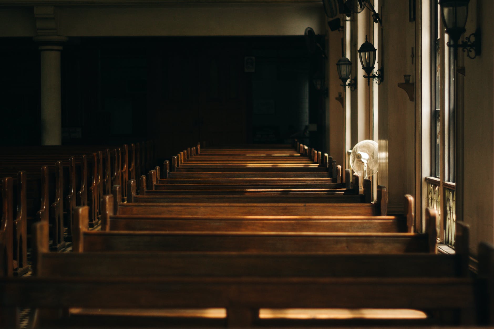 brown wooden church bench near white painted wall